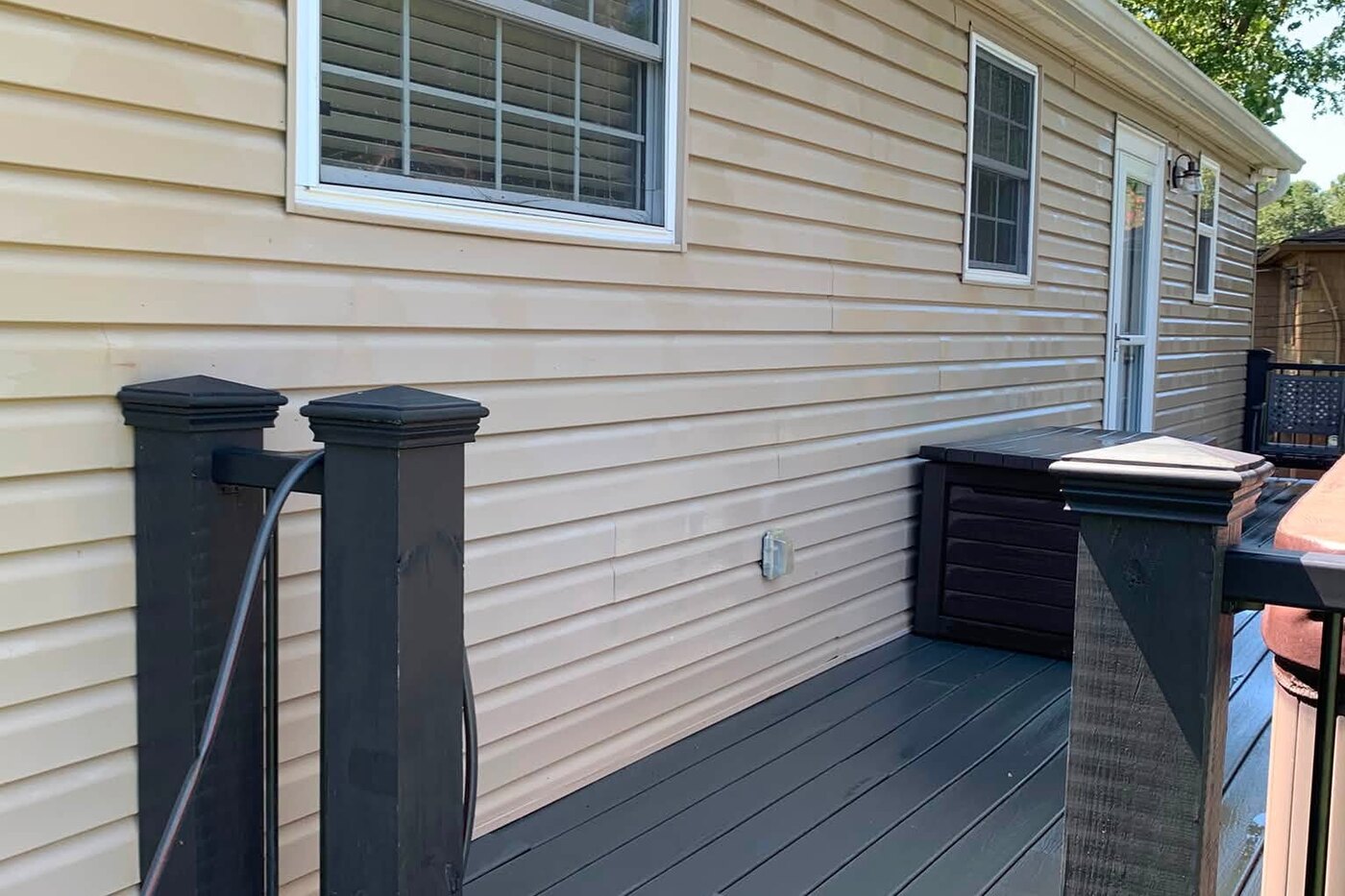 The same siding and deck after washing, the siding clean and the decking dark and even