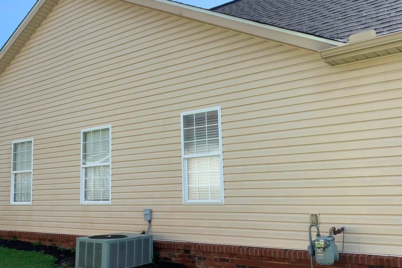 The same gable after a soft wash, the siding and brick clean and even