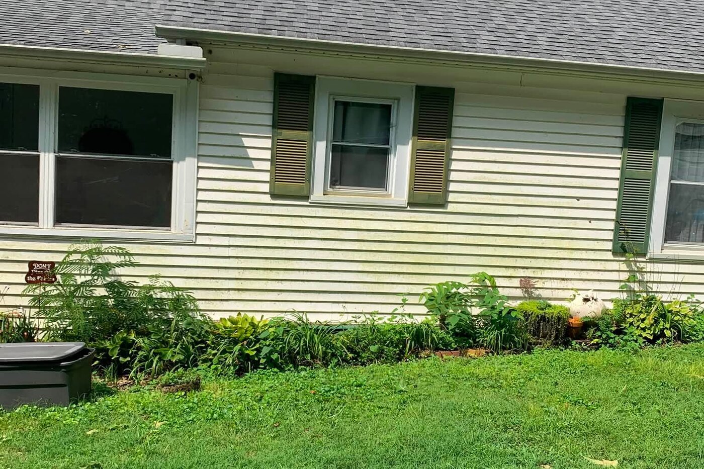 The same ranch home after a soft wash, the siding and shutters clean