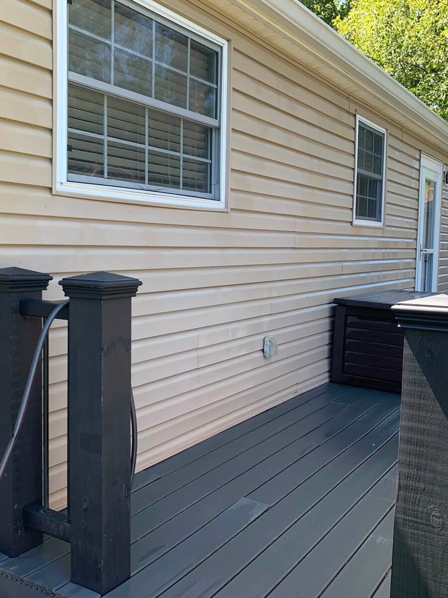 A cleaned deck and the washed house siding behind it